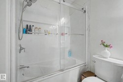 Bathtub with sliding glass enclosure and integrated shower niche - 