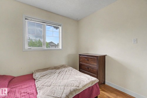 Bright room featuring a large window with white trim, wood-finish flooring, and neutral wall paint - 710 Glenwright Court, Edmonton, AB 