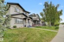 Stucco exterior with contrasting trim, gable rooflines, covered front porch with white railings, and mature landscaping - 710 Glenwright Court, Edmonton, AB 