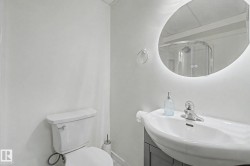 Contemporary bathroom vanity with integrated sink, chrome faucet, and backlit oval mirror - 