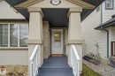 Front entry with a covered porch featuring stucco columns and railings - 710 Glenwright Court, Edmonton, AB 