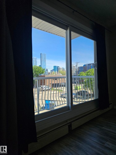 Sliding glass door opening to a balcony with white metal railing - 301 10615 110 Street Nw, Edmonton, AB 