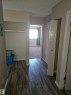 Interior hallway featuring wood-finish flooring, neutral wall tones, and white baseboards - 301 10615 110 Street Nw, Edmonton, AB 