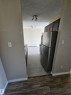 Kitchen entrance featuring wood-finish flooring transitioning to rectangular tile flooring - 301 10615 110 Street Nw, Edmonton, AB 