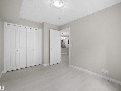 Room featuring light wood-finish flooring and neutral wall tones - 220 12035 22 Avenue, Edmonton, AB 