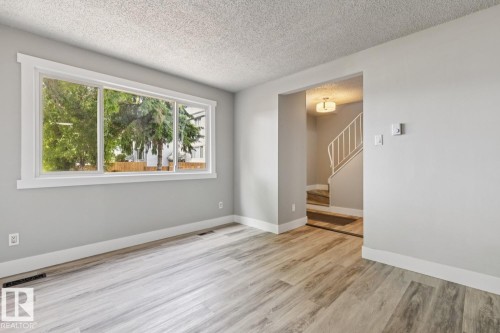 Light gray walls complement the wood-finish flooring - 75 Mcleod Place, Edmonton, AB 