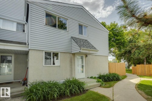 Light-colored siding exterior with a contrasting stucco foundation - 75 Mcleod Place, Edmonton, AB 