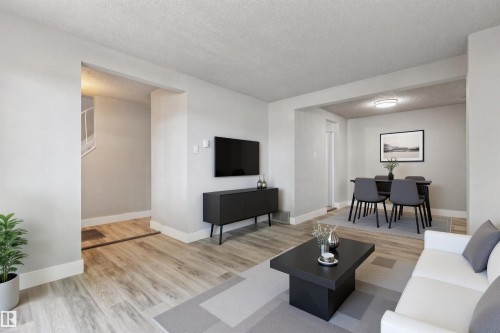 Expansive living area featuring light wood-finish flooring, white baseboards, and a neutral color palette - 75 Mcleod Place, Edmonton, AB 