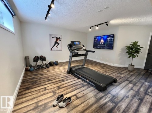 Versatile room featuring wood-finish flooring, recessed lighting, and track lighting - 10 Erickson Close, St. Albert, AB 
