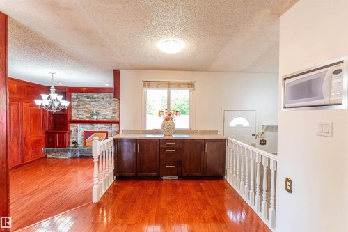Hardwood-finish flooring throughout, complemented by dark wood cabinetry with a light-toned countertop - 16524 116 Street, Edmonton, AB 