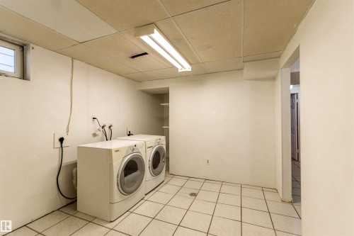 Dedicated laundry area featuring white tile flooring and a drop ceiling - 16524 116 Street, Edmonton, AB 