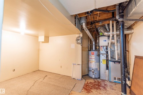 Basement utility area featuring a water heater, furnace, and exposed ductwork - 16524 116 Street, Edmonton, AB 