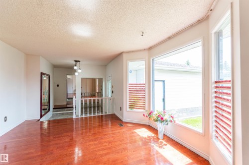 Hardwood-finish flooring throughout the main living area, complemented by a large bay window - 16524 116 Street, Edmonton, AB 