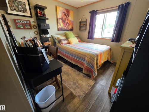 Compact room featuring wood-finish flooring, a single window with curtains, and a built-in wall shelf - 88B 3400 48 Street, Stony Plain, AB 