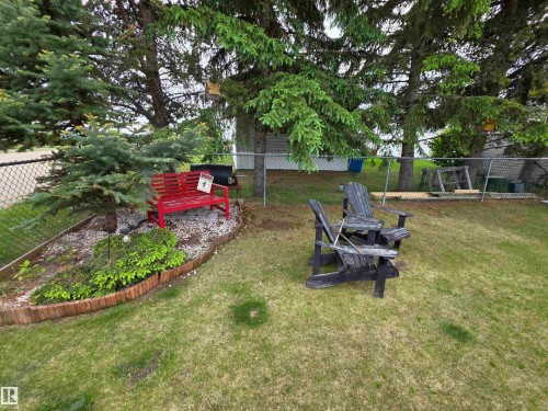 Green lawn with mature trees and a chain-link fence - 88B 3400 48 Street, Stony Plain, AB 