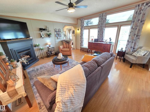 Open-concept living area featuring wood-finish flooring and a ceiling fan with integrated lighting - 88B 3400 48 Street, Stony Plain, AB 