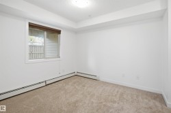 Carpeted interior space featuring a window with a brown roller blind, white baseboards, and white walls - 