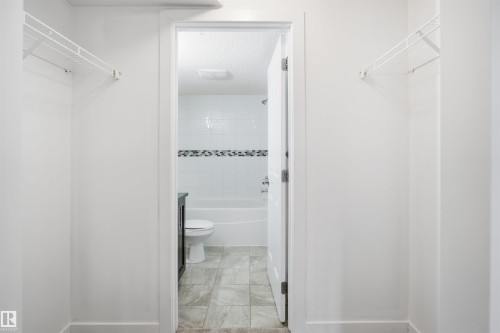 Walk-through closet featuring white wire shelving - 115 274 Mcconachie Drive, Edmonton, AB 