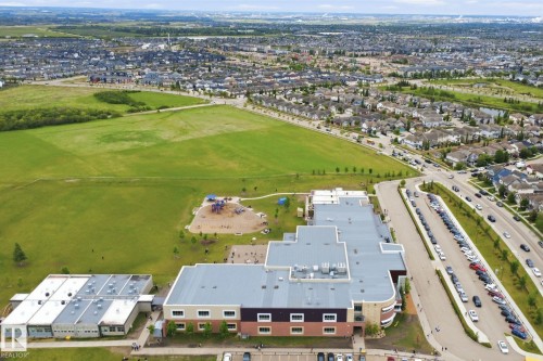 Aerial perspective showcasing expansive green spaces, structured buildings with flat roofs, and organized parking areas - 115 274 Mcconachie Drive, Edmonton, AB 