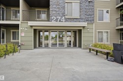 Building exterior featuring a stone facade accent, horizontal siding, and multiple balconies with dark railings - 