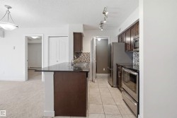 Kitchen featuring dark wood-finish cabinetry, stainless steel appliances, and a tiled backsplash - 