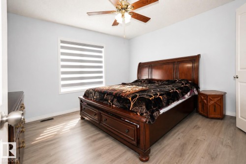 Bedroom featuring light gray walls and wood-finish flooring - 8523 7 Avenue Sw, Edmonton, AB 