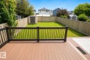 Expansive backyard featuring a fenced perimeter, green lawn, and a storage shed - 8523 7 Avenue Sw, Edmonton, AB 