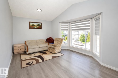 Expansive room featuring a prominent bay window with multiple panes and white trim - 8523 7 Avenue Sw, Edmonton, AB 