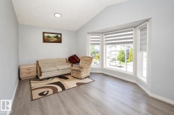 Expansive room featuring a prominent bay window with multiple panes and white trim - 