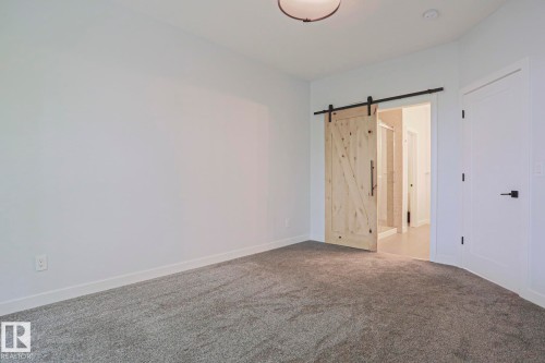 Spacious room featuring gray carpet flooring and white baseboards - 10628 81 Street Nw, Edmonton, AB 