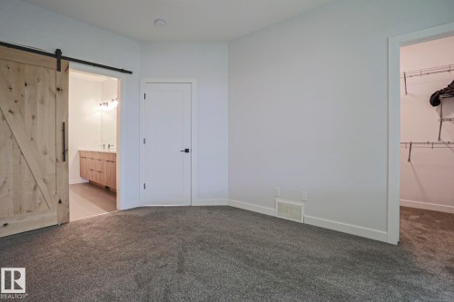 Spacious room featuring gray carpet flooring, white baseboards, and a white wall finish - 10628 81 Street Nw, Edmonton, AB 