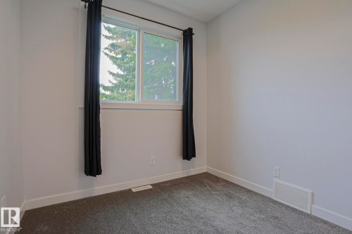 Neutral paint palette bedroom featuring gray carpeting and white trim - 10628 81 Street Nw, Edmonton, AB 