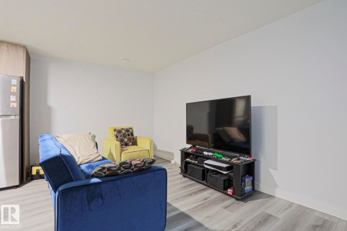 Open-concept living area featuring light wood-finish flooring, white walls, and recessed lighting - 10628 81 Street Nw, Edmonton, AB 