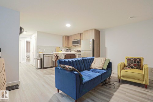 Open-concept living space featuring wood-finish flooring, recessed lighting, and white walls - 10628 81 Street Nw, Edmonton, AB 