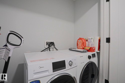 Dedicated laundry area featuring light gray wall paint and a white door with black hardware - 10628 81 Street Nw, Edmonton, AB 