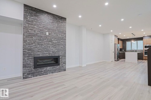 Spacious interior featuring wide plank wood-finish flooring and recessed lighting - 10628 81 Street Nw, Edmonton, AB 