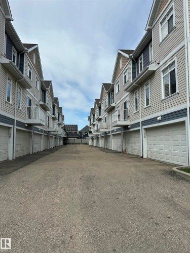 Exterior townhome architecture featuring light beige and dark blue siding - #31 1804 70 St Sw, Edmonton, AB - Outdoor
