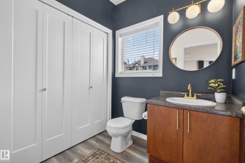 Vanity featuring a gold-finish faucet, undermount sink, and wood-tone cabinetry with gold-tone hardware - 57 3010 33 Avenue, Edmonton, AB 