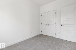 Neutral wall paint, plush carpeting, white trim, modern interior doors, and matte black hardware - 