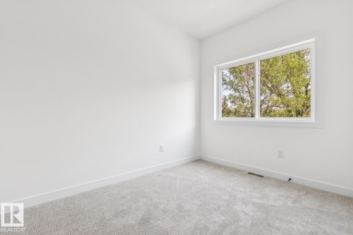 Large window, light gray carpeting, white walls, white trim - 11336 130 Street Nw, Edmonton, AB 