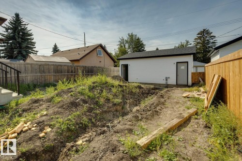 Detached structure with white siding and dark shingle roofing, featuring two entry doors - 11336 130 Street Nw, Edmonton, AB 
