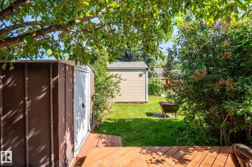 Deck area with wood-finish flooring extending to a storage shed with white door - 14708 108 Av, Edmonton, AB 