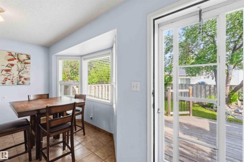 Tiled flooring in a bright dining area featuring a bay window with blinds - 18808 72A Avenue, Edmonton, AB 