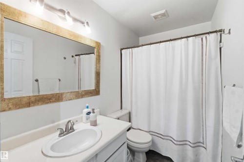 Bathroom vanity with an integrated sink and a framed mirror - 18808 72A Avenue, Edmonton, AB 