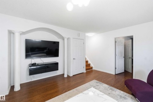 Open-concept living area featuring wood-finish flooring and bright white walls - 18808 72A Avenue, Edmonton, AB 