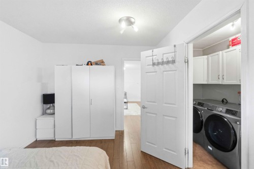 Dedicated laundry area featuring white upper cabinetry and a dark countertop - 18808 72A Avenue, Edmonton, AB 