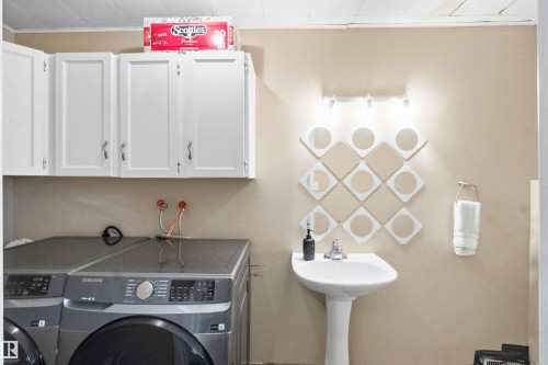Laundry area featuring white upper cabinetry, a pedestal sink, and a wall-mounted towel ring - 18808 72A Avenue, Edmonton, AB 