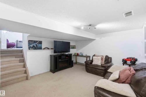 Carpeted recreation room featuring white walls and a drop ceiling - 18808 72A Avenue, Edmonton, AB 
