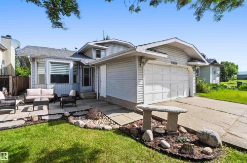 Single-story residence featuring light gray siding, an attached garage, and a concrete driveway - 18808 72A Avenue, Edmonton, AB 