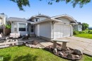 Single-story residence featuring light gray siding, an attached garage, and a concrete driveway - 18808 72A Avenue, Edmonton, AB 